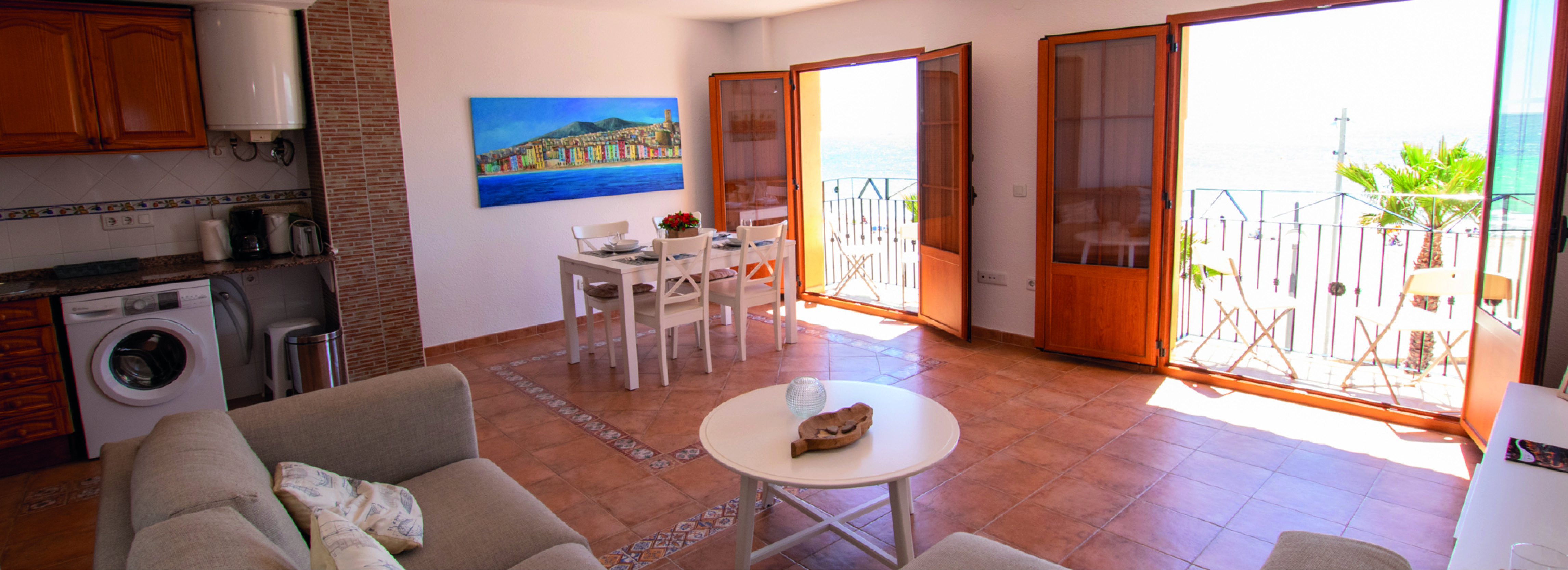 Lys og stor stue med stor sofa som vender mot utsikten – leiligheten har vaskemaskin på kjøkkenet