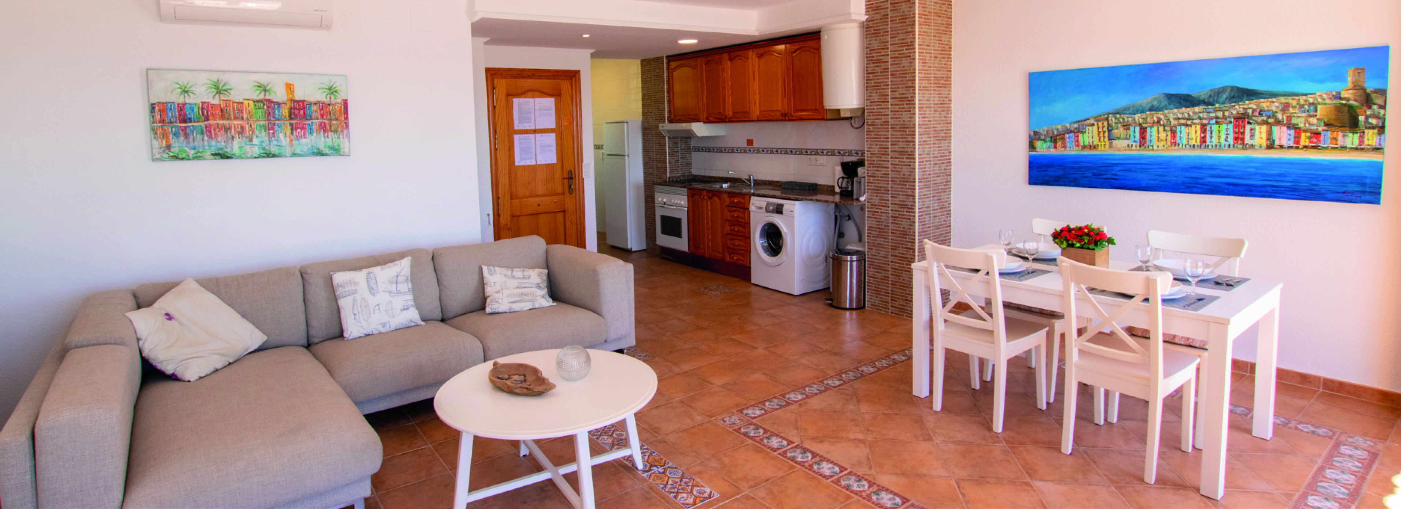 Spisebord med plass til fire personer – kjøkkenet har komfyr og vaskemaskin