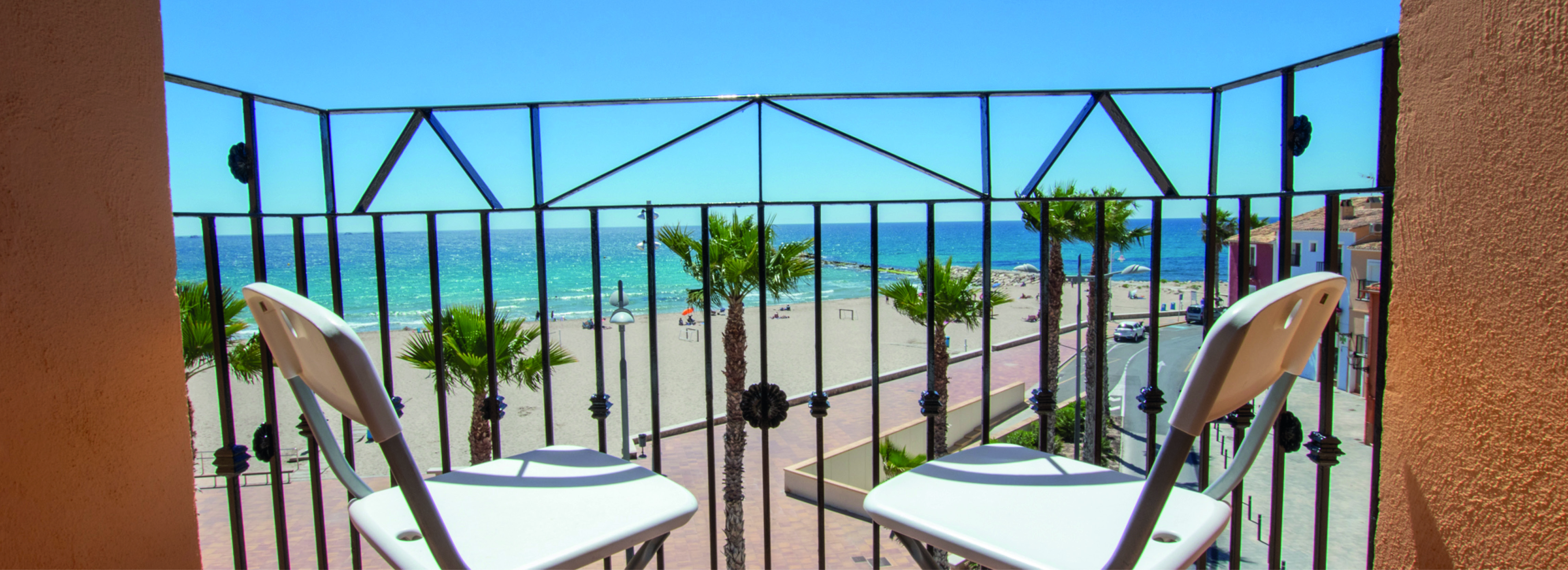 Balkong med plass til et bord og to stoler som har fantastisk utsikt mot havet